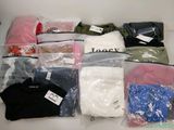 beaucoup de vêtements dans des sacs posés sur une table