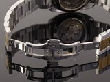 a close up of a watch on a reflective surface