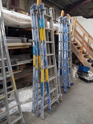 many ladders that are stacked up in a warehouse