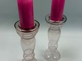 deux bougies roses posées sur une table