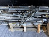 un tas de tuyaux métalliques posés sur une palette dans un entrepôt
