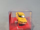 a yellow toy car in a clear box on a red carpet