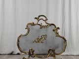 un pare-feu de cheminée richement décoré, orné d'un motif à la feuille d'or