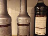 three bottles of liquid sitting on a counter next to each other