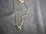 a close up of a gold necklace with a flower on it