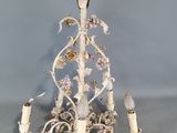 un lustre blanc orné de fleurs et de bougies