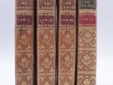 three old books sitting on top of each other on a white surface