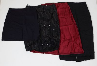 trois paires de pantalons noirs, rouges et noirs posés sur une surface blanche