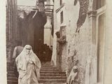 an old photo of a woman walking down a set of stairs
