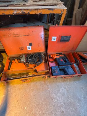 deux boîtes orange contenant des outils, posées par terre