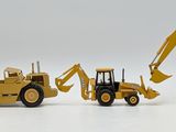 three toy construction vehicles that are lined up on a table