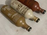three empty bottles sitting on a counter next to each other