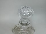 a glass candle holder with a flower on top of it