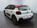 the rear end of a white and red citrole parked in a room