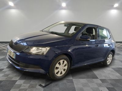 La voiture bleue est garée sur un sol carrelé à damier.