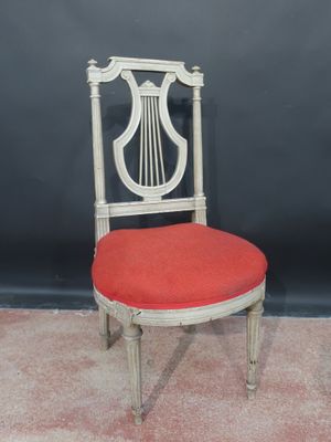 a white chair with a red cushion and a harp on the back