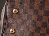 a close up of a brown and black checkered purse