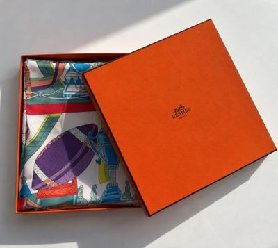 an orange box with a pair of socks in it on a white surface