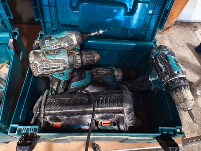 deux outils électriques dans une boîte à outils bleue posée par terre