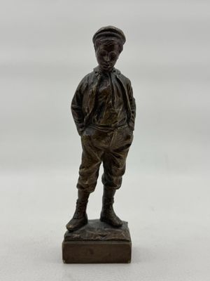 figurine en bronze représentant un garçon debout sur un socle en bois