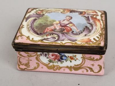 une boîte rose et dorée sur laquelle figure l'image d'une femme