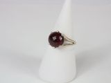 a close up of a ring with a red stone on it