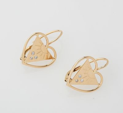 a pair of gold earrings with diamonds in the shape of a heart