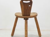 a small wooden chair with a wooden seat on a white floor
