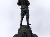 bronze statue of a man standing on top of a clock