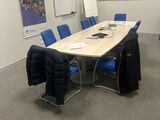 une photo d'une salle de conférence avec des chaises bleues et un écran de projection