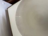 a white plate sitting on top of a table next to a wall