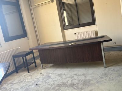 un bureau et une chaise dans une pièce dotée d'une fenêtre