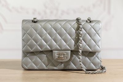 a silver purse sitting on a table with a chain around it
