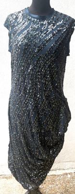 une robe noire posée sur un mannequin sur un trottoir