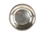 une assiette en argent posée sur un plateau blanc, bordée d'argent