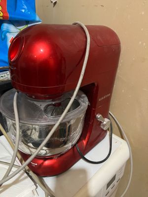 un robot ménager rouge posé sur un réfrigérateur blanc