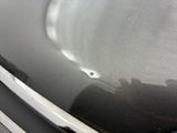a close up of a car ' s hood with a hole in the hood