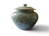 a blue vase with a lid sitting on a white surface
