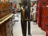 a statue of a person holding a pole in a store