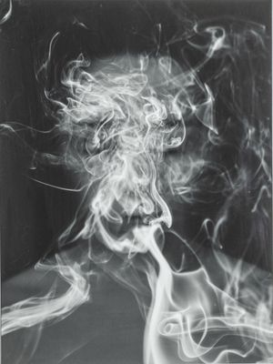 photographie en noir et blanc d'un homme dont de la fumée sort de la bouche