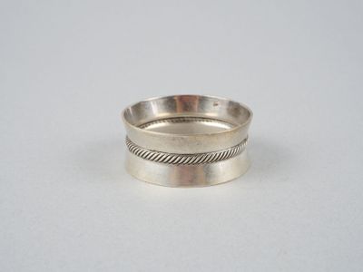 gros plan d'une bague en argent sur une surface blanche