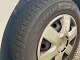 a white car with a flat tire on a gravel road