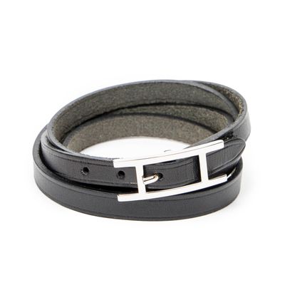 black leather bracelet with a silver buckle on a white background