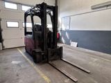 un chariot élévateur dans un entrepôt, avec une porte en arrière-plan