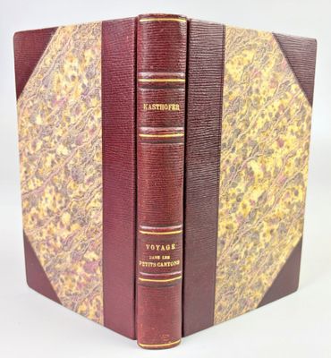 two books are stacked on top of each other on a white surface