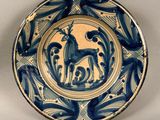 une assiette bleue et blanche sur laquelle est représenté un cerf