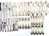 a lot of silver spoons and spoons on the table
