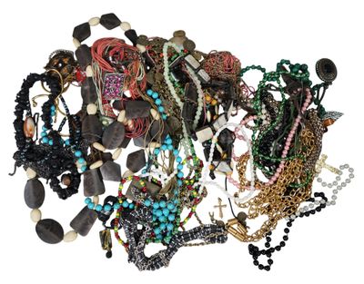 a pile of assorted necklaces and bracelets on a white surface