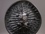 a close up of a metal object on a white surface