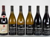 six bottles of wine are lined up on a table